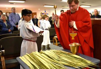 Father Edward Essig, pastor of St. Francis de Sales, Robesonia, blesses palms to be distributed to the faithful on Palm Sunday. The feast commemorates Jesus’ triumphant entry into Jerusalem the week before his passion and crucifixion. 