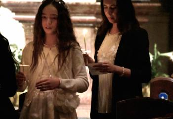 Angelina Funes, left, and Karlenis Solano Maza participate in the Liturgy of Baptism during the Easter Vigil.