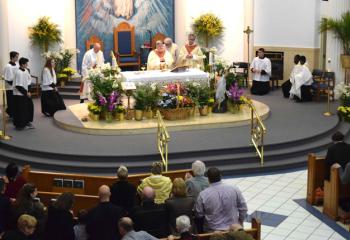 Bishop Alfred Schlert, center, celebrates the Mass at the regularly scheduled 10:30 a.m. Mass at Queenship of Mary. With him at the altar are, from left, Deacon Michael Doncsecz, Deacon William Urbine and Father Patrick Lamb. 