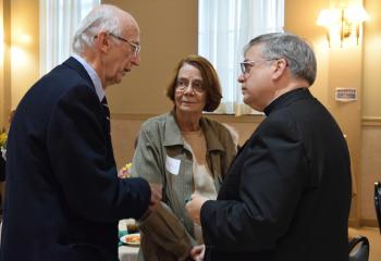 Dr. Augustine and Joanne Moffitt, parishioners of Our Lady of Perpetual Help, left, enjoy chatting with Bishop Alfred Schlert.
