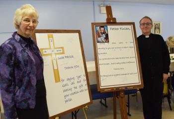 Sister Patricia Weidman, left, chaplain at the Federal Correctional Institution Schuylkill, and Father Finlan, pastor, stands alongside posters signed by parishioners.