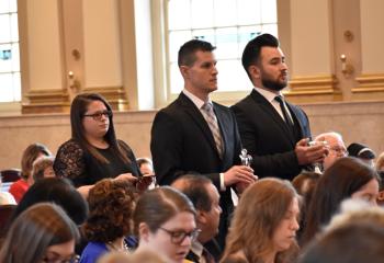 Presenting the offertory gifts are, from left, Emily Wehr, Justin Esposito and James Maria.