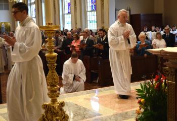 Deacon candidates, from left, Giuseppe Esposito, Zachary Wehr and John Maria enter the sanctuary at the beginning of the Mass.