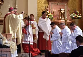 Bishop Alfred Schlert extends his hands over the deacon candidates, from left, Giuseppe Esposito, John Maria and Zachary Wehr during the Prayer of Consecration, the form of the Sacrament of Holy Orders. At the completion of this prayer, the three men are ordained deacons. At left is Monsignor Victor Finelli.