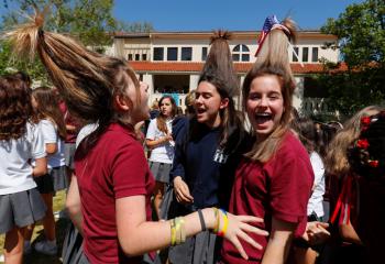 Students at Immaculate Heart High School in Los Angeles wear their hair up like hats May 15 during a celebration for Meghan Markle's upcoming marriage to Prince Harry. Markle is an alumna of the school. (CNS photo/Mike Blake, Reuters)