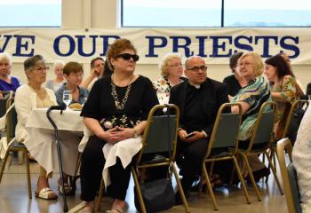 Father Robert George, pastor of Sacred Heart, Bethlehem, joins other guests in listening to Bishop Alfred Schlert’s remarks. (Photo by John Simitz)