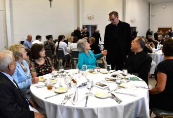 Father John Hutta, standing, greets the group from the Cathedral of St. Catharine of Siena, Allentown, from left: Rich and Marie Mazzini; Connie Karg; Kathy Duff; Father Bernard Ezaki, assistant pastor of St. Jane Frances de Chantal, Easton and former assistant pastor of the Cathedral; and Beverly McDevitt, director of music at the Cathedral. (Photo by John Simitz)