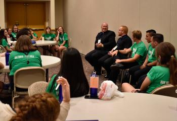 Father Allen Hoffa, center, and Father Mark Searles talk with Fiat Days participants during a question and answer panel discussion so the girls can ask priests and seminarians questions and the boys can ask the sisters questions about their life and vocation.