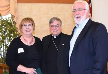 Bishop Schlert, center, welcomes Bonnie and James Foley as members of the Legacy Society.