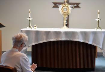 A woman spends time in adoration at St. Thomas More. (Photo by John Simitz)