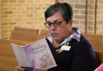 A woman reads “Healing Thoughts” during adoration at St. Mary. (Photo by Sue Braff)