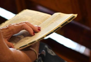 A woman reads the Bible during adoration at St. Ambrose. (Photo by John Simitz)