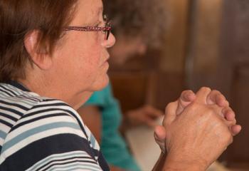 A woman joins fellow parishioners in praying during exposition at Our Lady of Perpetual Help. (Photo by Sue Braff)
