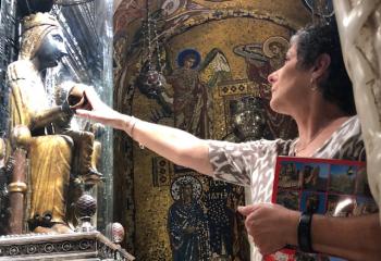 Kim Bucari, parishioner of Queenship of Mary, Northampton, touches La Moreneta, Catalonia’s miraculous and beloved statue of the Black Virgin of Montserrat at Montserrat Monastery, Catalonia, Spain.