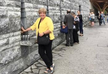 Diane Cortazzo fills bottles with water in Lourdes.