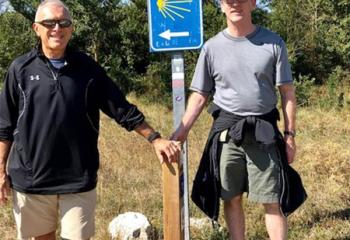 Mike Grasso, left, and Father Patrick Lamb pause in the sunshine on the Camino de Santiago (Way of St. James) walk near Burgos, Spain.