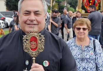 Father Joseph Corpora, director of University-School Partnerships in the Alliance for Catholic Education at the University of Notre Dame, Ind., whose home parish is St. Anthony of Padua, carries a relic of San Placido during the 3-mile procession Sept. 2, past houses of the society members.