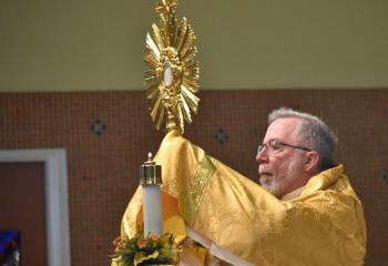 Deacon Carlin displays the Holy Eucharist for adoration and meditation at Sacred Heart. (Photo by John Simitz)