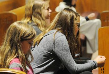 The Stratton family prays the rosary during the Holy Hour. From left are Monica Stratton, Martha Stratton and Molly Stratton. (Photo by Ed Koskey)
