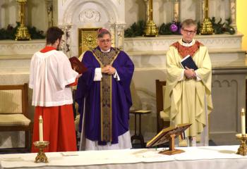 Bishop Alfred Schlert, center, celebrates the liturgy, with Father Lamb, right and altar server Brandon Becker. 