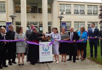 Celebrating the Ribbon Cutting are, from left: Dominick Coppola, board of directors vice chair; Father Patrick Lamb, board member and pastor of Queenship of Mary, Northampton; Wendy Krisak, board member; John Petruzzelli, principal; Bishop Alfred Schlert; Brooke Tesche; Ashley Russo (behind Tesche); Linda Johnson, board member; Michael Balsama, board member; Anita Jo Paukovits, board member; John Freeh (hidden), board member; and Michael Metzger, board chair. (Photo courtesy of Jessica Edris)