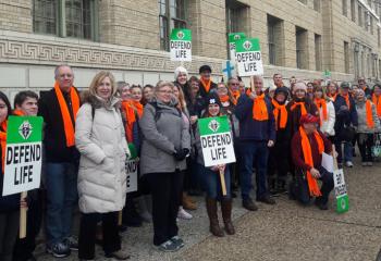The group from St. Joseph the Worker Parish, Orefield, many wearing orange scarves, pauses for a photo during the march. (Photo courtesy of Sue Mueller)
