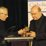 The Rev. Msgr. Walter T. Scheaffer, President of Catholic Charities, Diocese of Allentown Board of Directors, left, presents the Most Rev. Edward P. Cullen, D.D., Bishop of Allentown, with a medallion recognizing his generosity to Catholic Charities. Msgr. Scheaffer made the presentation at the first annual Catholic Charities Gala to honor Bishop Cullen’s 10th anniversary as Bishop of Allentown Feb. 10, 2008 at the Holiday Inn, Fogelsville. 