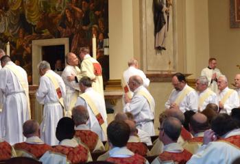 Deacons offer the fraternal Kiss of Peace to Deacon John Hutta as a sign of welcoming into the Order of Deacons. (Photo by John Simitz)