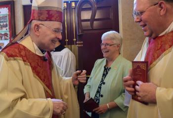 Msgr. David James, right, director of the diocesan Office for Vocations, welcomes Bishop Cullen to the cathedral before the ceremony. (Photo by John Simitz)