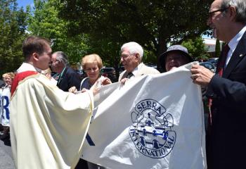 Father Rother thanks members of the Serra Clubs of the Diocese of Allentown holding a sign expressing their support: “We Love Our Priests.” (Photo by John Simitz)