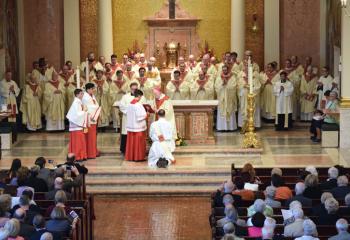 Bishop Cullen and priests of the Diocese of Allentown and Archdiocese of Philadelphia pray the Prayer of Ordination as Father Rother kneels. (Photo by John Simitz)