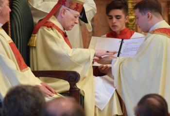 Bishop Cullen anoints the hands of Father Rother with sacred chrism during Anointing of the Hands. (Photo by John Simitz)