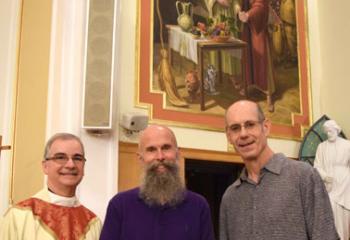 Father Mongiello, left, meets with Stephen Buell, center, who modeled for the mural, and artist Dana Van Horn, right. 