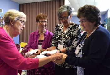 Sister of Mercy Sister Janice Marie Johnson blesses the hands of, from left, Barbara Malewski, Karen Wallace and Helen DiGirolomo. (Photo by John Simitz)