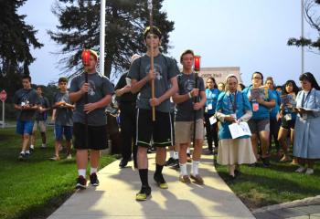 Quo Vadis and Fiat campers join with clergy and religious sisters July 19 in the outdoor Stations of the Cross. (Photo by John Simitz)