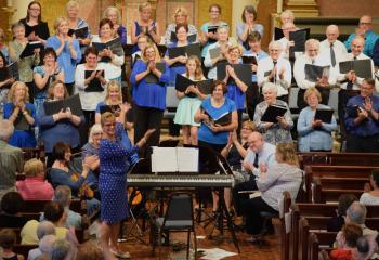 Beverly McDevitt and the Combined Choir receive applause after performing several selections honoring Mary during the Marian Concert.