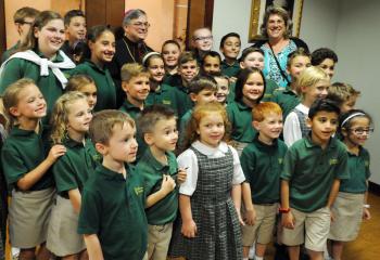 Bishop Schlert, back, stands with students of St. Jane Frances de Chantal School, Easton and Principal Marybeth Okula, right, after celebrating Mass. “The Church needs your youthfulness,” Bishop Schlert told the students.