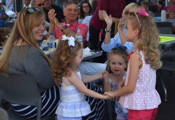 From left, Molly, Lily and Lucy Newman dance as their family watches. (Photo by John Simitz)