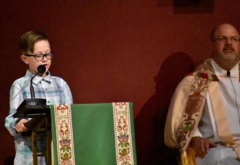 Milo Moser, student at Our Lady of Perpetual Help School, Bethlehem, offers the First Reading at St. Elizabeth. (Photo by John Simitz)