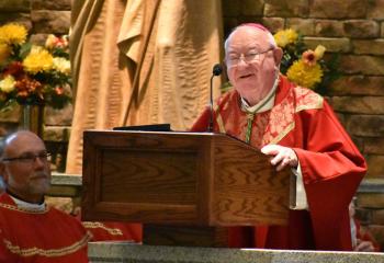 Msgr. Edward Domin, left, listens as Bishop William Murphy preaches the homily.