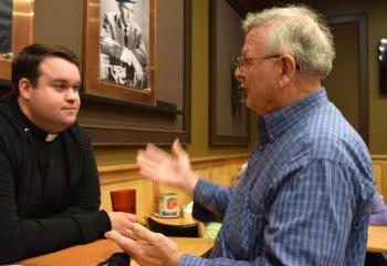 Steve Babinchak talks with Father Rick James during the evening event.