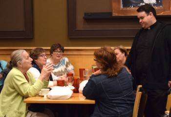 Dora Santarecci, left, asks Father Rick James a question as Theresa Panchison and Lucy O’Connor, seated next to her, listen for his answer.