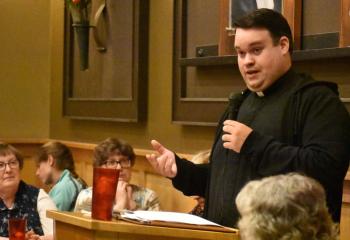 Theresa Panchison and Lucy O’Connor, left, listen as Father Rick James discusses the message of Fatima and Divine Mercy.