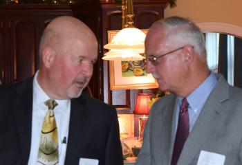 Paul Wirth, board chair of Catholic Charities, left, talks with Michael McGrail during the event.