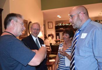 Barry Schmura, left, talks to Gary (Rob) Laubenheimer, case worker for Catholic Charities’ Veterans Support Services program. In back are Bob Wert and Joann Schmura.