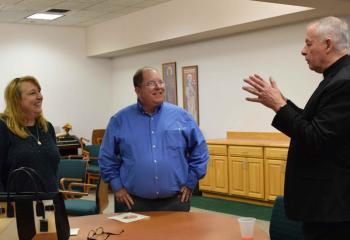 Father Kaminski, right, replies to a question from Anne Marie and Tim Ferguson during the break.