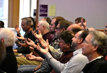 Men pray together by asking the Holy Spirit for greater guidance.