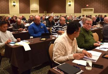 Father George Winne, assistant pastor of Sacred Heart of Jesus, Allentown, front, second from left, is among the priests of the Diocese listening attentively at this year’s convocation.