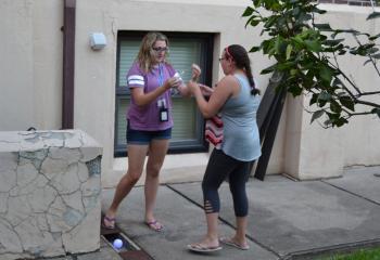 Kendall Decker of Our Lady of Mount Carmel, Roseto and Rachel Miller of Queenship of Mary, Northampton put on their light-up cross necklaces designating them as “Saved” after finding The Light while playing “Save the Lost.” (Photo by Alexa Doncsecz)