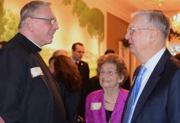 Msgr. Gerald Gobitas, left, speaks with William and Rose Scharle.